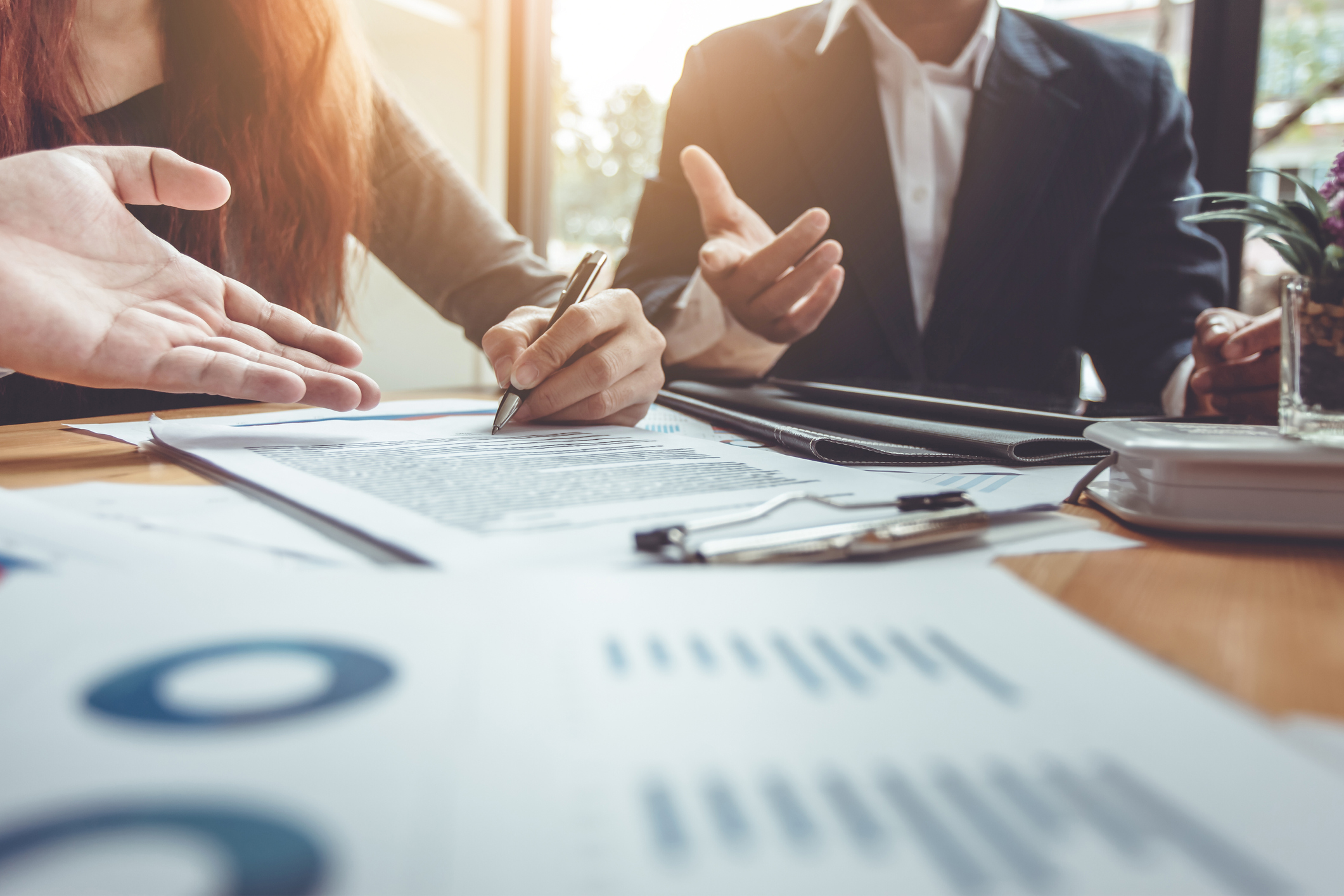 Two business people around a table with investment documents