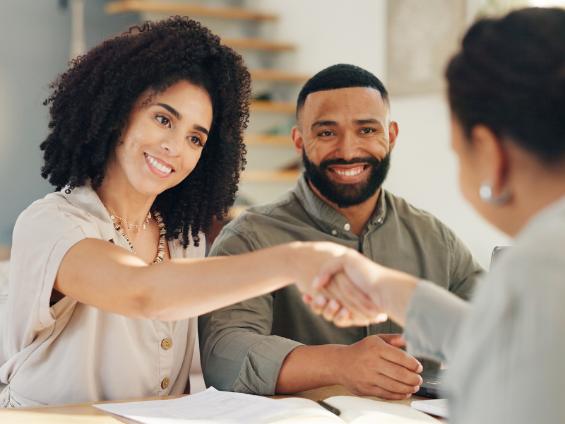 Family shaking hands finalizing their mortgage deal